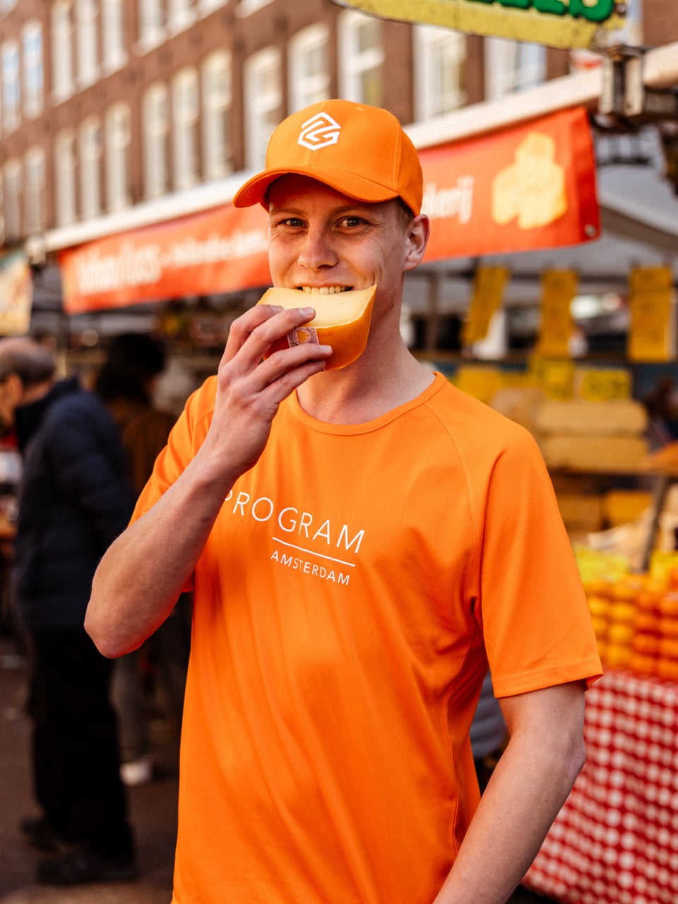 Guy biting cheese in orange program shirt