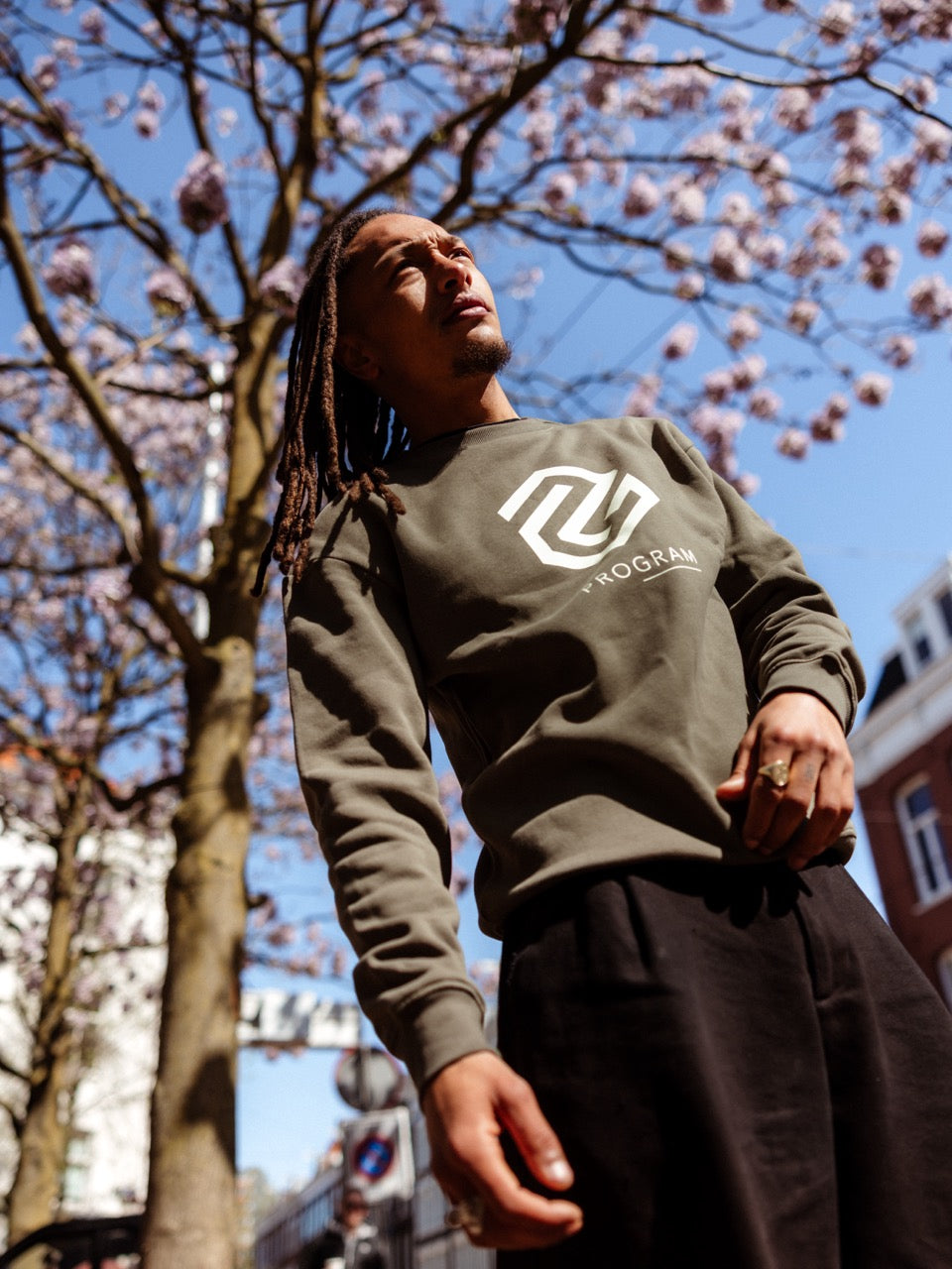 Guy wearing olive green program sweater with logo