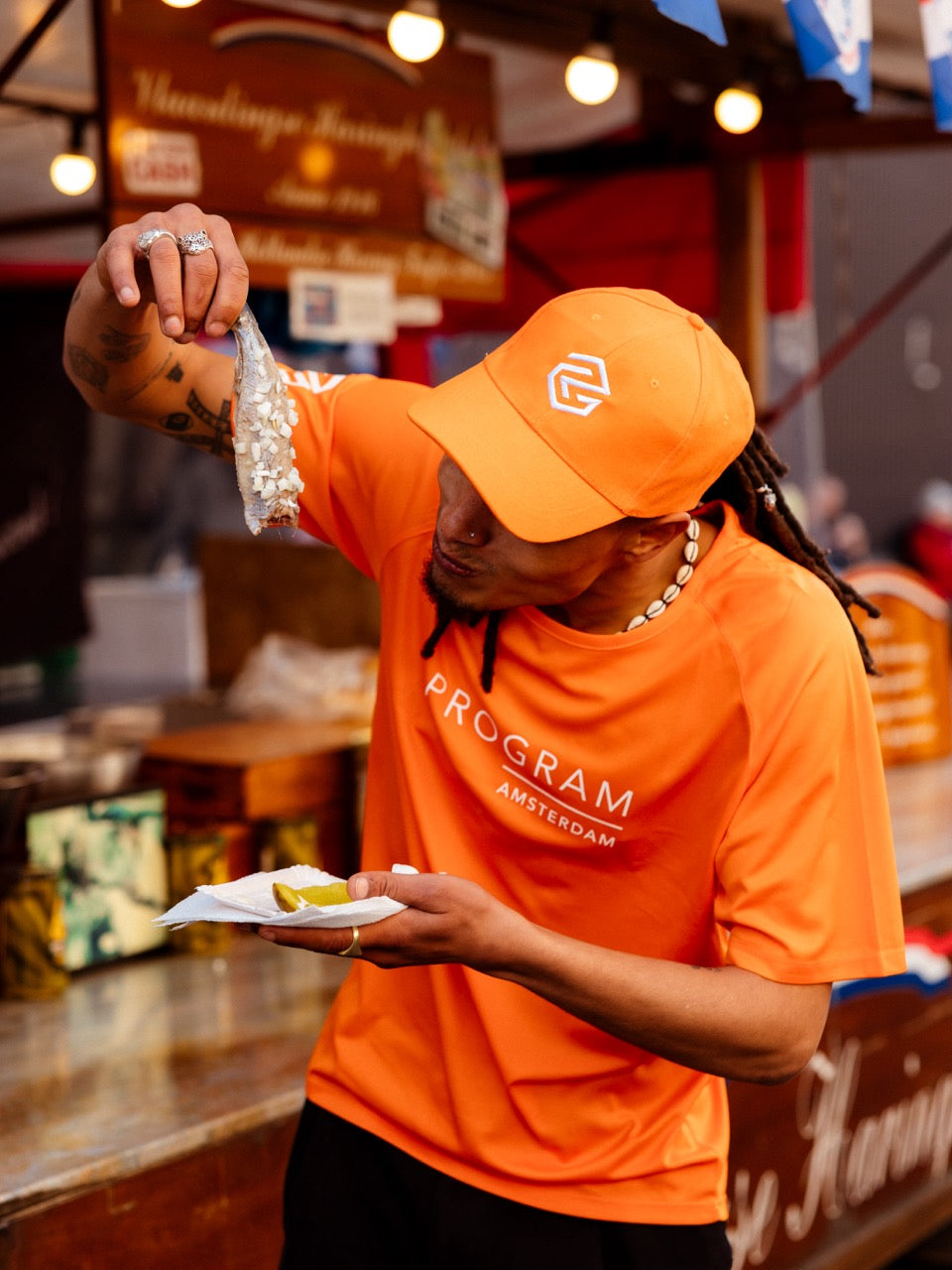 Eating hearing with orange program cap and shirt